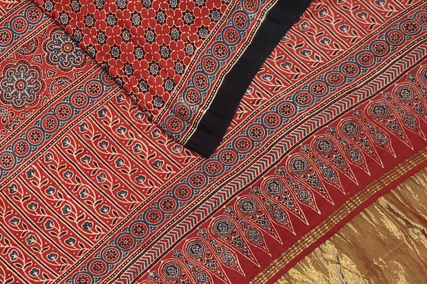 Modal silk saree in red with floral motifs  in hand block ajrakh print and a tissue pallu