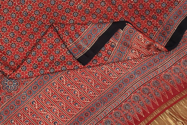 Modal silk saree in red with floral motifs  in hand block ajrakh print and a tissue pallu