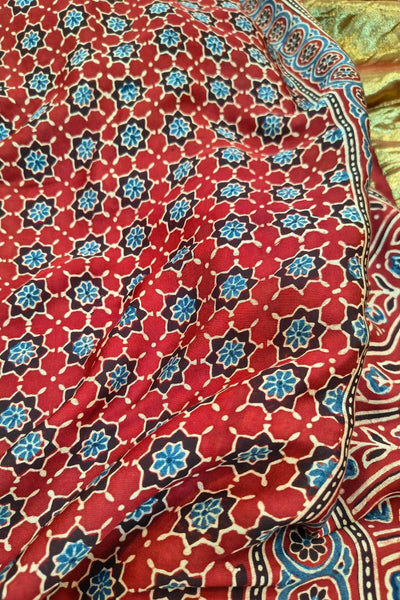 Modal silk saree in red with floral motifs  in hand block ajrakh print and a tissue pallu