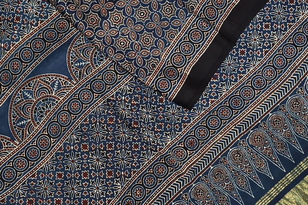 Modal silk saree in blue with floral motifs  in hand block ajrakh print and a tissue pallu