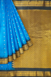 Gadwal pure silk saree in  blue with small floral motifs in gold .