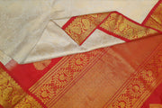 Handwoven Gadwal silk brocade saree in off white with floral motifs on the body