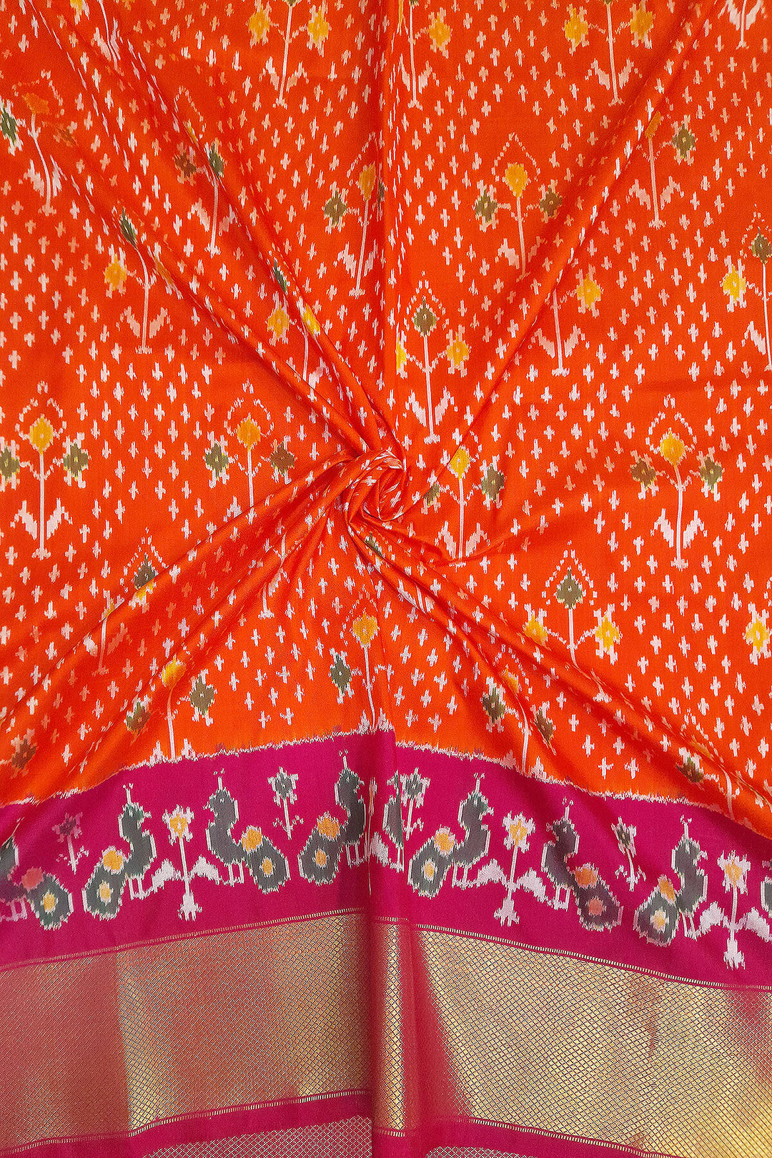 Handwoven Ikat pure silk unstitched lehenga material in orange  with plant motifs.