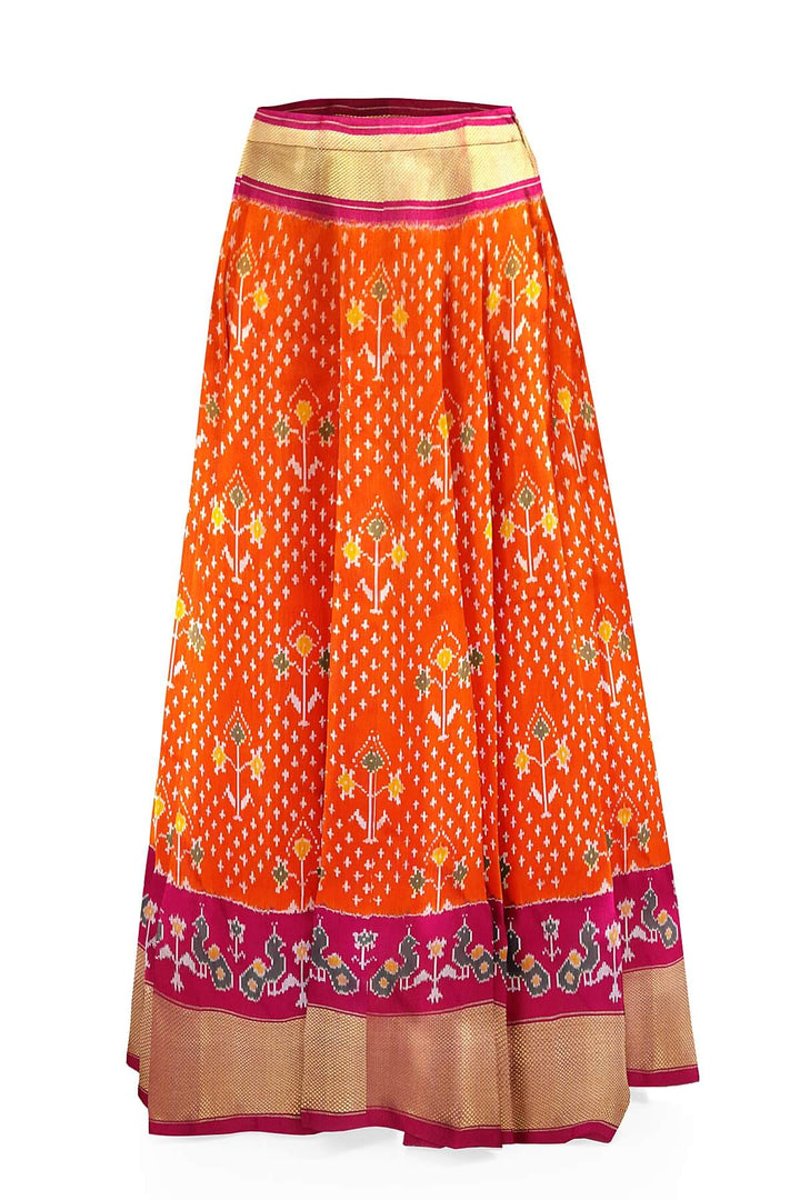Handwoven Ikat pure silk unstitched lehenga material in orange  with plant motifs.