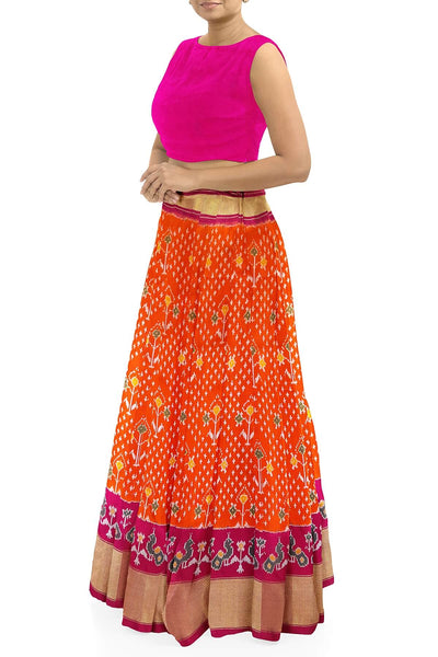 Handwoven Ikat pure silk unstitched lehenga material in orange  with plant motifs.