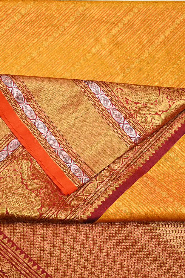 Handwoven Kanchi pure silk  brocade saree in mustard , accentuated with peacock motifs in the border