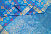 Kanchi pure silk saree in blue with floral motifs .