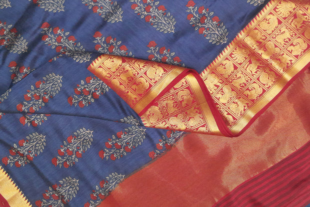 An  electric blue shade moonga silk saree with  copper red weaved zari border.