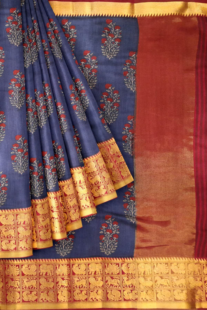An  electric blue shade moonga silk saree with  copper red weaved zari border.