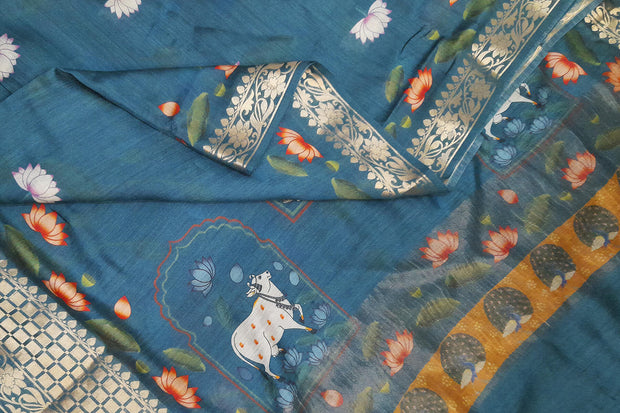 The pichwai with cow and lotus motifs .The gorgeous moonga saree has beautiful handwoven zari  borders